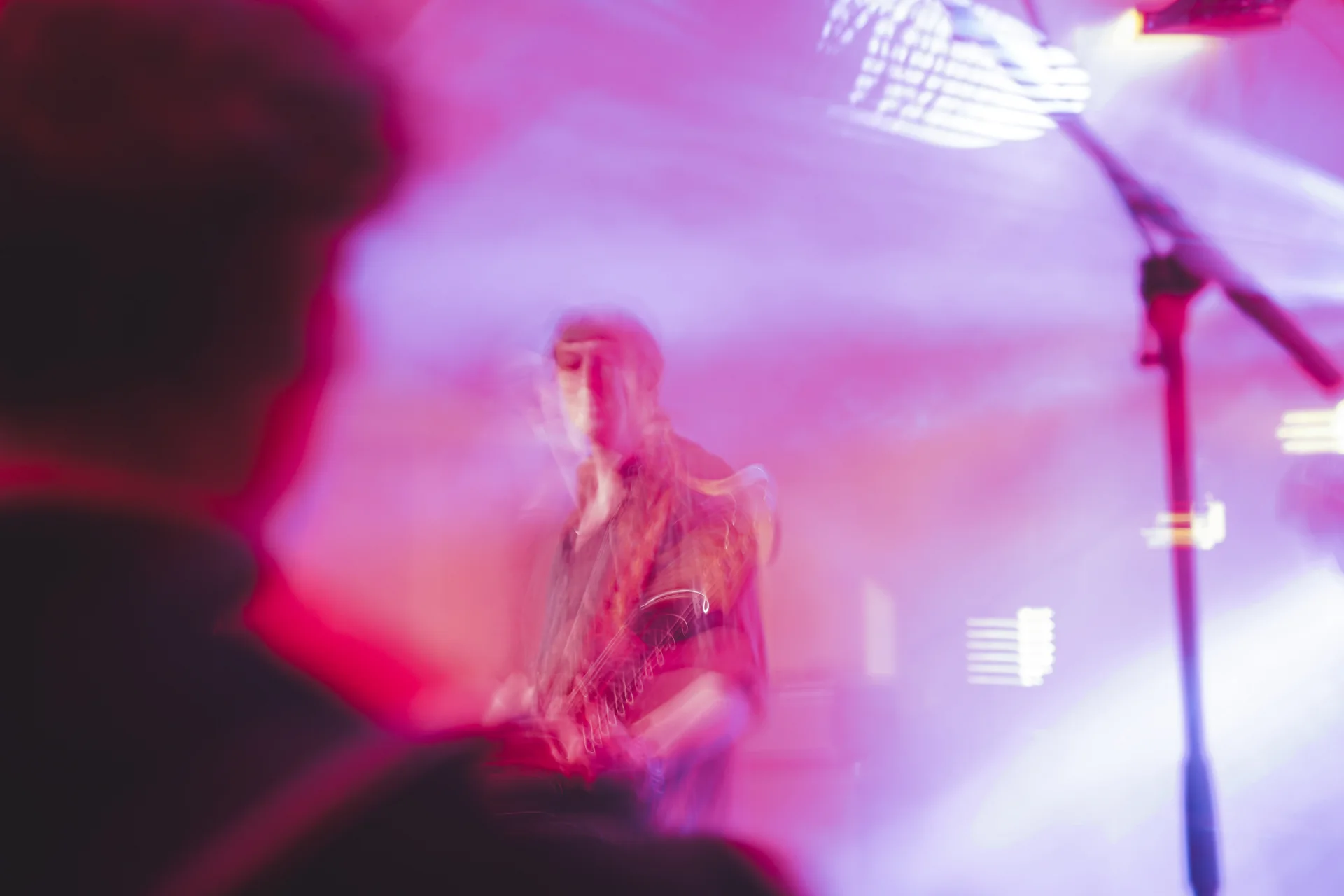 Singer surrounded by pink and white stage lighting